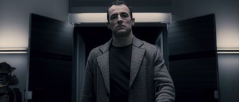 Movie still from “Chrysalis” (2007), directed by Julien Leclercq – A man standing in front of an escalator; Medium shot, Low angle