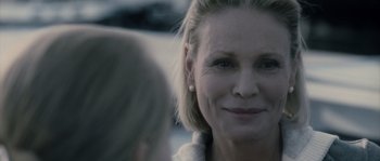 Movie still from “Chrysalis” (2007), directed by Julien Leclercq – An older woman is smiling at a younger woman; Close Up shot, Over the shoulder angle