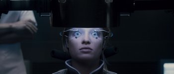 Movie still from “Chrysalis” (2007), directed by Julien Leclercq – A woman wearing a helmet and goggles with blue lights on her eyes; Close Up shot, High angle
