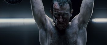 Movie still from “Chrysalis” (2007), directed by Julien Leclercq – A shirtless man with blood all over his face and arms; Close Up shot, Low angle