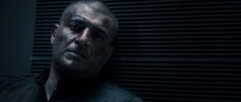 Movie still from “Chrysalis” (2007), directed by Julien Leclercq – A person with a bruise on his face; Close Up shot, Low angle