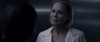 Movie still from “Chrysalis” (2007), directed by Julien Leclercq – An older woman in a white jacket looking at the camera; Close Up shot, Over the shoulder angle