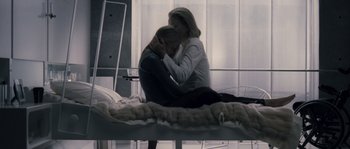 Movie still from “Chrysalis” (2007), directed by Julien Leclercq – Two women sitting on a bed one is hugging the other; Medium shot, Over the shoulder angle