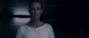 Movie still from “Chrysalis” (2007), directed by Julien Leclercq – A woman in a white shirt is looking at the camera; Close Up shot, Low angle