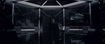 Movie still from “Chrysalis” (2007), directed by Julien Leclercq – A person sitting in a room with a lot of lights; Wide shot, Overhead angle