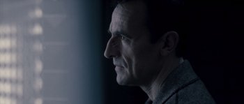 Movie still from “Chrysalis” (2007), directed by Julien Leclercq – A person's face in a dark room; Close Up shot, Low angle