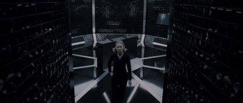 Movie still from “Chrysalis” (2007), directed by Julien Leclercq – A woman standing inside of a room in a building; Wide shot, Low angle