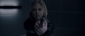 Movie still from “Chrysalis” (2007), directed by Julien Leclercq – A woman is holding a gun in a dark room; Close Up shot, Low angle