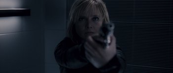 Movie still from “Chrysalis” (2007), directed by Julien Leclercq – A woman holding a gun in a dark room; Close Up shot, Low angle