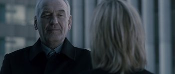 Movie still from “Chrysalis” (2007), directed by Julien Leclercq – An older man in a black jacket and a woman in a black jacket; Close Up shot, Over the shoulder angle