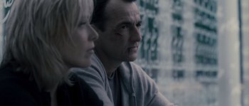 Movie still from “Chrysalis” (2007), directed by Julien Leclercq – A man and a woman sitting next to each other in front of a window; Close Up shot, Over the shoulder angle