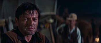 Movie still from “Cimarron” (1960), directed by Charles Walters – A person wearing a cowboy hat; Close Up shot, Over the shoulder angle