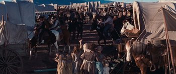 Movie still from “Cimarron” (1960), directed by Charles Walters – A group of people standing around a crowd of people on horses; Extreme Wide shot, High angle