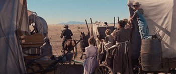 Movie still from “Cimarron” (1960), directed by Charles Walters – A group of people riding horses on a dirt field; Wide shot, High angle