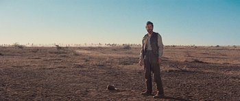 Movie still from “Cimarron” (1960), directed by Charles Walters – A man standing in the middle of an empty field; Wide shot, Low angle