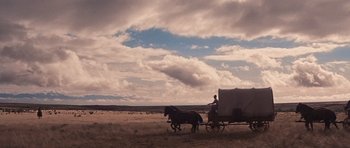 Movie still from “Cimarron” (1960), directed by Charles Walters – Two horses pulling a carriage in a field; Extreme Wide shot, Low angle