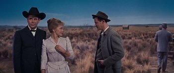 Movie still from “Cimarron” (1960), directed by Charles Walters – A man and a woman talking in a field; Medium shot, Over the shoulder angle