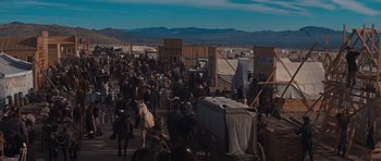 Movie still from “Cimarron” (1960), directed by Charles Walters – A crowd of people walking on a dirt road; Extreme Wide shot, High angle