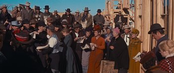 Movie still from “Cimarron” (1960), directed by Charles Walters – A group of people standing next to each other on a field; Wide shot, High angle