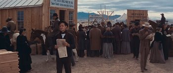 Movie still from “Cimarron” (1960), directed by Charles Walters – A crowd of people standing in front of a building; Wide shot, Over the shoulder angle