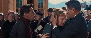 Movie still from “Cimarron” (1960), directed by Charles Walters – A woman covering her ears with her hands while a man stands next to her; Close Up shot, Over the shoulder angle