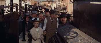 Movie still from “Cimarron” (1960), directed by Charles Walters – A group of people standing in the middle of a street; Wide shot, High angle