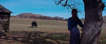 Movie still from “Cimarron” (1960), directed by Charles Walters – A woman standing in the middle of an open field; Wide shot, Over the shoulder angle