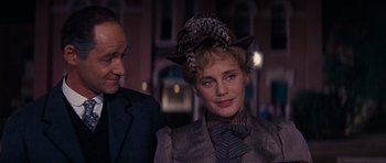 Movie still from “Cimarron” (1960), directed by Charles Walters – A man and a woman wearing suits and a hat; Close Up shot, Over the shoulder angle