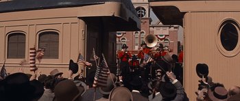 Movie still from “Cimarron” (1960), directed by Charles Walters – A group of men in red jackets playing musical instruments; Extreme Wide shot, High angle