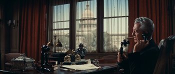 Movie still from “Cimarron” (1960), directed by Charles Walters – A view of the capitol building from a desk; Medium shot, Low angle