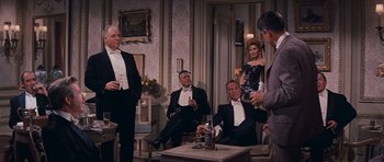 A group of men in tuxedos sitting in a living room