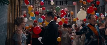 Movie still from “Cimarron” (1960), directed by Charles Walters – A man in a tuxedo standing in front of a group of people; Medium shot, Low angle