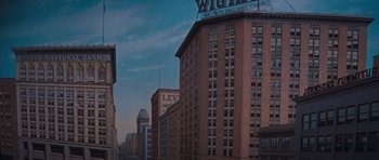 Movie still from “Cimarron” (1960), directed by Charles Walters – A tall brick building on a city street; Extreme Wide shot, Low angle