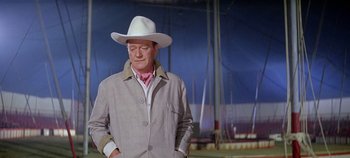Movie still from “Circus World” (1964), directed by Henry Hathaway – An older man wearing a cowboy hat and a jacket; Medium shot, Low angle