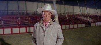 Movie still from “Circus World” (1964), directed by Henry Hathaway – A man wearing a cowboy hat standing in an arena; Medium shot, Low angle