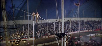 Movie still from “Circus World” (1964), directed by Henry Hathaway – Two men are on a high wire in front of an audience; Wide shot, High angle