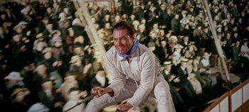 Movie still from “Circus World” (1964), directed by Henry Hathaway – A man riding a horse in front of a crowd of people; Medium shot, Overhead angle