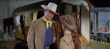 Movie still from “Circus World” (1964), directed by Henry Hathaway – A man and a woman wearing cowboy hats; Medium shot, Over the shoulder angle
