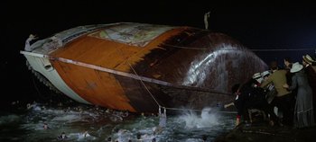 Movie still from “Circus World” (1964), directed by Henry Hathaway – A group of people standing on top of a boat in the water at night; Extreme Wide shot, High angle