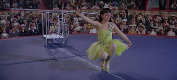 Movie still from “Circus World” (1964), directed by Henry Hathaway – A girl in a yellow dress is performing a dance; Medium shot, High angle