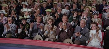 Movie still from “Circus World” (1964), directed by Henry Hathaway – A group of people sitting and clapping in a stadium; Wide shot, High angle