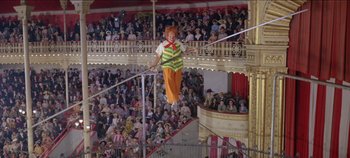 Movie still from “Circus World” (1964), directed by Henry Hathaway – A man is balancing on a bar in front of an audience; Extreme Wide shot, High angle