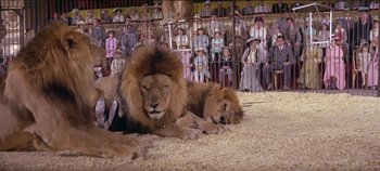 Movie still from “Circus World” (1964), directed by Henry Hathaway – A couple of lions that are sitting in the dirt; Wide shot, Low angle