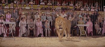 Movie still from “Circus World” (1964), directed by Henry Hathaway – A crowd of people watching a lion in an arena; Wide shot, High angle