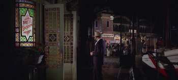Movie still from “Circus World” (1964), directed by Henry Hathaway – A man in a suit and a cowboy hat walking down a street; Wide shot, High angle