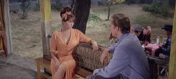 Movie still from “Circus World” (1964), directed by Henry Hathaway – A man and a woman are sitting on a bench; Medium shot, Over the shoulder angle