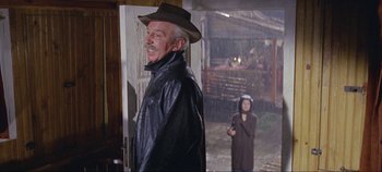 Movie still from “Circus World” (1964), directed by Henry Hathaway – An older man in a leather jacket and a young woman in a black dress; Medium shot, Over the shoulder angle