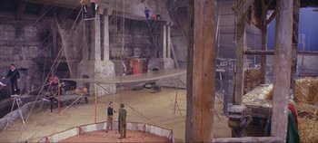 Movie still from “Circus World” (1964), directed by Henry Hathaway – Two men standing in an arena with a rope; Extreme Wide shot, High angle