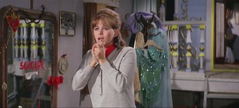 Movie still from “Circus World” (1964), directed by Henry Hathaway – A woman in a gray sweater and red scarf; Medium shot, Over the shoulder angle