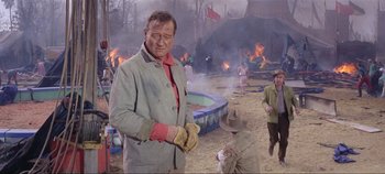 Movie still from “Circus World” (1964), directed by Henry Hathaway – An old man standing in front of a crowd of people; Medium shot, Over the shoulder angle